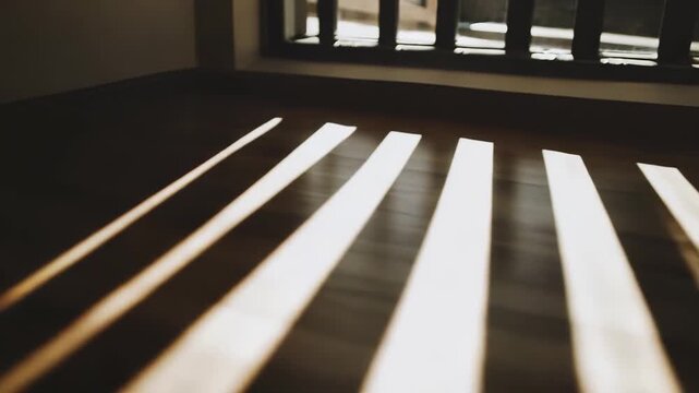 Sunlight beams through a window, casting geometric striped shadows across a textured wooden floor, warm morning light creating a minimal, tranquil interior pattern and contrast