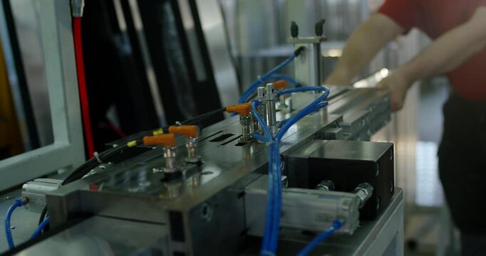 Industrial automated pneumatic machinery with blue hoses in factory