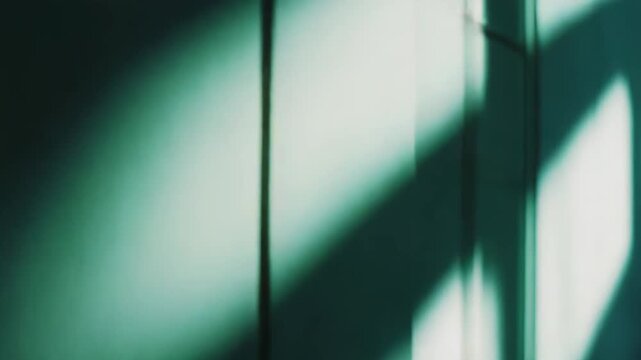 Geometric shadow patterns from a window are casting dramatic light and dark shapes across a textured architectural wall, creating an abstract and moody visual composition