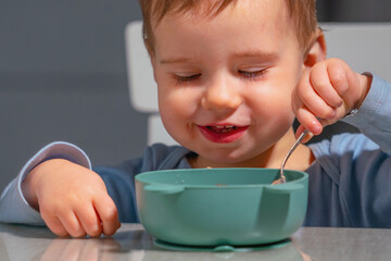 Child enjoying healthy cereal while practicing coordination and self care skills.