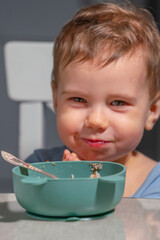 Toddler eating cereal alone, showing confidence and independence at home.