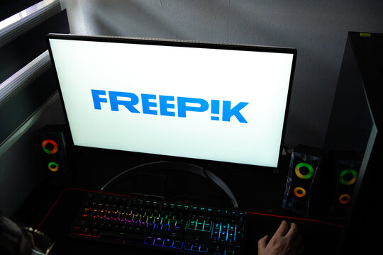 Punta Arenas, Chile &ndash; February 18, 2026: A person at a desk with the Freepik creative platform logo displayed on a computer monitor