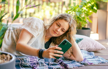 Happy Woman Using Smartphone on Summer Terrace