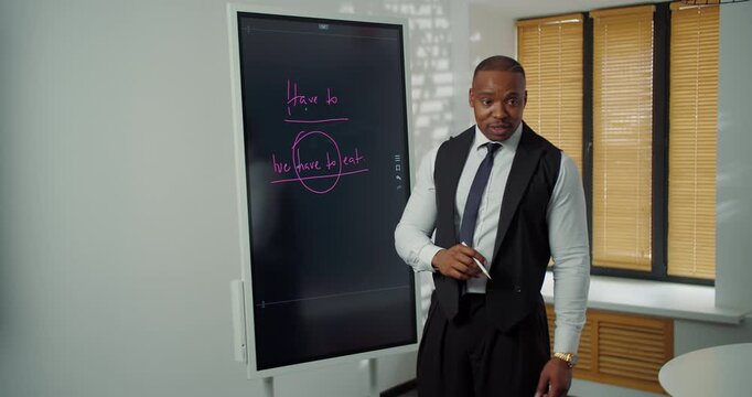 Teacher explaining English grammar on digital board