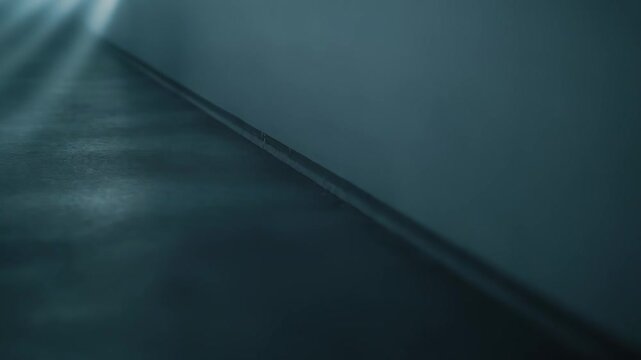 Light beams entering through a window and creating a repeating pattern of bright stripes and dark shadows on a grey textured surface, offering an abstract background for design