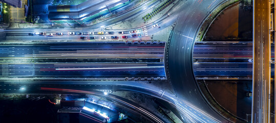 Obraz na płótnie Canvas Expressway top view, Road traffic an important infrastructure, car traffic transportation above intersection road in city night, aerial view cityscape of advanced innovation, financial technology