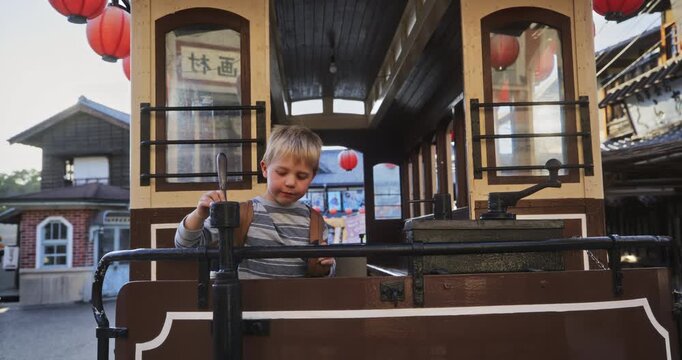 Little boy playing on old Japanese trolly - medium, steady cam movement