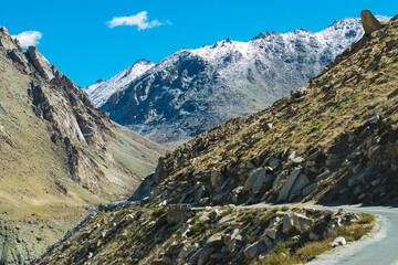 High altitude motorable road with snowy Himalayan peaks, at Chang La,southern pass, high mountain pass in Ladakh in the Greater Himalaya , from Leh to Pangong Lake road. Leh, Ladakh, India.