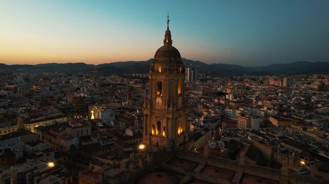 Panoramic view of Malaga city, Spain. Malaga cityscape with beautiful Cathedral of the incarnation at sunset. Panning shot of old town, Cathedral and skyline of city. Slow panning. Religion concept
