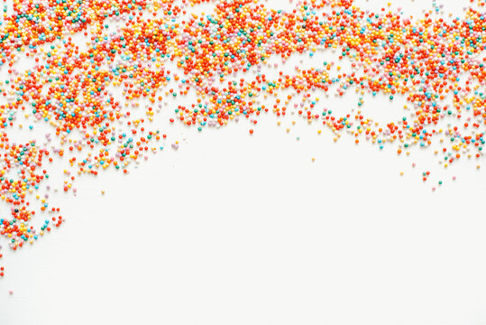 Colored sprinkles on a white background. Sprinkles for Easter cakes. Bright background. Confectionery sprinkles.