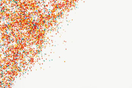 Colored sprinkles on a white background. Sprinkles for Easter cakes. Bright background. Confectionery sprinkles.