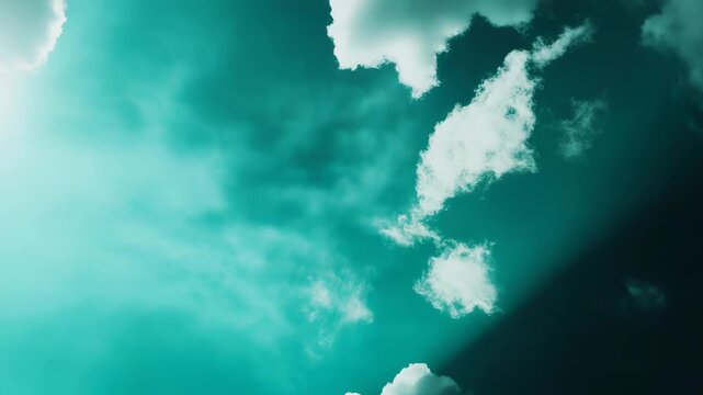 Bright sunrays breaking through fluffy white clouds on a vibrant teal blue sky, creating a calming and ethereal natural background with a sense of peace and hope