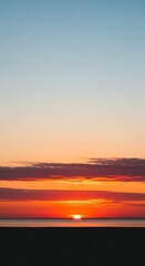 Obraz premium Vibrant orange sunset over ocean horizon.