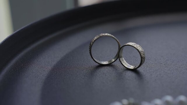 Wedding gold rings captured from an unusual angle, slow motion. Contemporary style