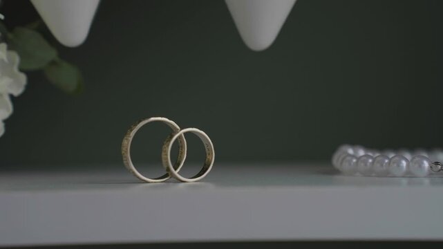 Wedding gold rings captured from an unusual angle, slow motion. Contemporary style