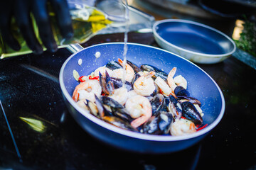 Apetyczne małże i krewetki smażone na patelni © Artur