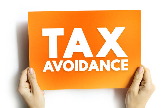 TAX AVOIDANCE text on card held by hands. Concept image representing financial planning, accounting, legal methods of minimizing tax payments, and corporate strategy