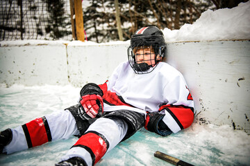 Obraz premium Depress and sad Ice hockey player outside in uniform. Sports winter games outdoors in winter.