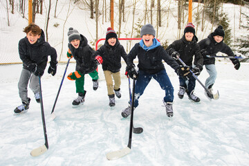 Ice hockey group of teen play hockey outside in winter. Sports winter games outdoors in winter.