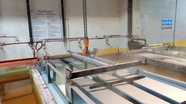 Metal cabinets immersed in chemical pretreatment tanks for rust removal before powder coating