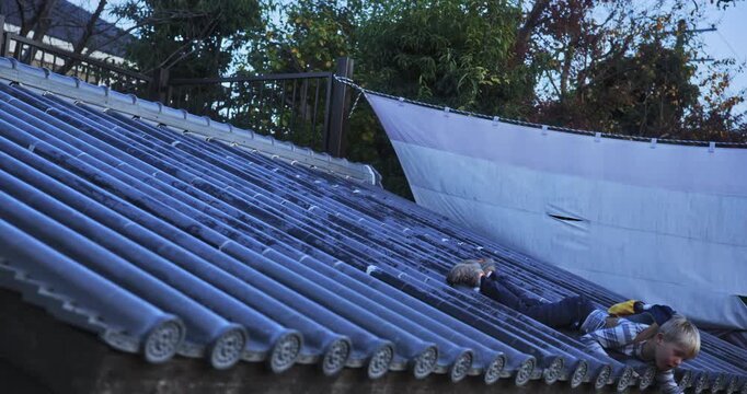 Silly boy pretending to fall off prop Japanese roof