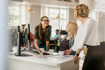 Fototapeta premium Coworkers laughing during coffee break in modern office