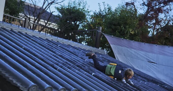 Kid with backpack stumbling down Japanese rooftop set