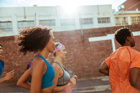 Young adults jogging together on urban street