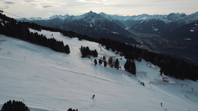 Panorama skiing with the best mountain landscape is absolute freedom. Aerial top view ski turns on a steep ski slope in a glacier ski resort high up in the alps with fresh snow. Cold winter day skiing