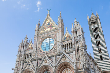 Naklejka premium Siena cathedral in Italy. White marbles with blue sky, famous landmark of Tuscany.