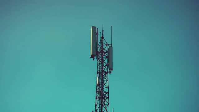 Telecommunication tower standing tall against a clear blue green sky, actively transmitting radio and cellular signals for global mobile network connectivity and digital communication