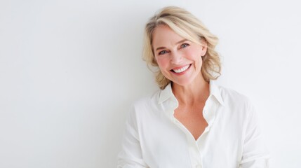 Obraz premium Smiling caucasian mature female in white shirt against white background.