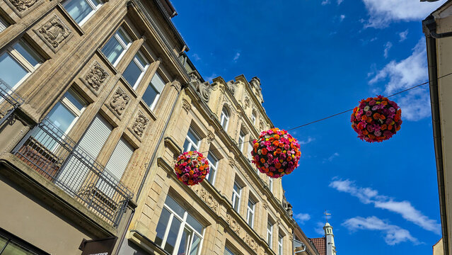 The colorful flower balls hanging on the street in the old town of Konstanz on Lake Constance in Germany. Easter mood. Summer mood.