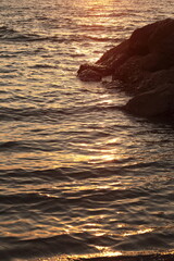 Golden Hour Reflections on Ocean Ripples with Coastal Rocks