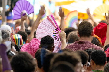 Fototapeta premium Foliões com leques e fantasias coloridas pulando carnaval em blocos de Carnaval de rua da cidade de São Paulo. Carnaval 2026. 
