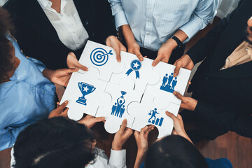 Diverse corporate officer workers collaborate in office, connecting puzzle pieces to represent...