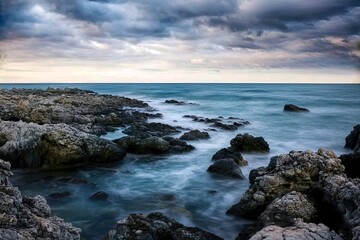 Dramatic coastal cliff landscape in Calabria with stormy weather and dark clouds, Italy