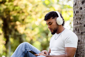 Young man relaxing outdoors listening music with headphones © Djavan Rodriguez