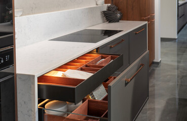Open kitchen drawer with wooden organizer in luxury interior