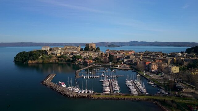 Capodimonte Marina Aerial View with Seagull Flying. Lake Bolsena Italy Mediterranean Aesthetics. Cinematic Drone Pedestal Shot of Sailing Boats and Italian Lakeside Village Architecture 4K