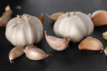 Fresh Whole Garlic Bulbs and Cloves on Dark Textured Background