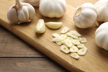 Fresh garlic bulbs and cloves on wooden table, closeup