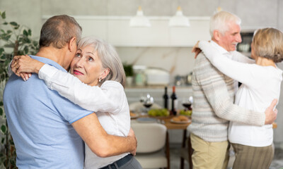Fototapeta premium Couple dance at a house party in an apartment for elderly friends