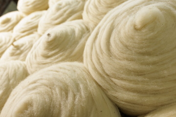 Merino wool fiber rolls texture background for textile production industry © st.kolesnikov