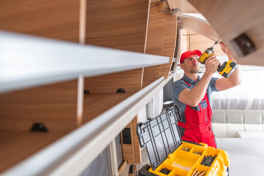 Worker Installs Shelf in Modern RV Camper Kitchen Space With Tools