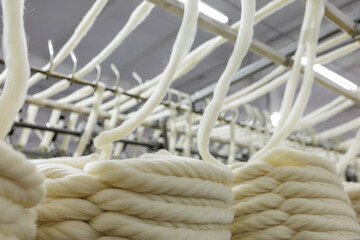 Merino wool yarn winding on industrial textile production machinery © st.kolesnikov