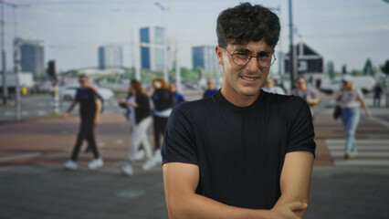 Fototapeta premium Man clutching his left arm and grimacing on a street crosswalk amid blurred pedestrians; discomfort vulnerability.