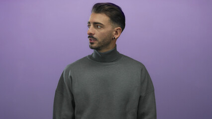 Obraz premium Young hispanic man wearing gray turtleneck cups hands around mouth shouting in studio with focused expression; urgency.
