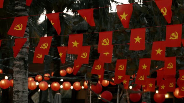 Red Flags with Star and Hammer Sickle on Tropical Night Street