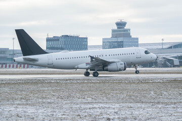 Generic white unbranded Airbus A319 passenger airplane on snowy airport runway in winter